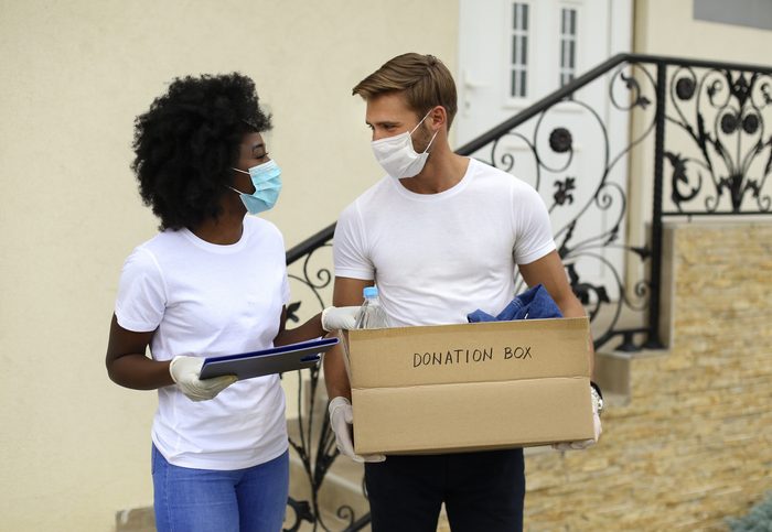 Couple iwth mask holding donation box