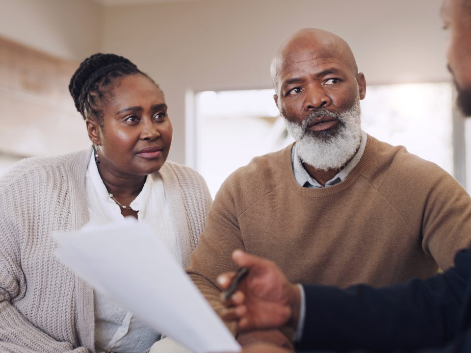 Cropped shot of a senior couple sitting with their financial advisor in their home during the day